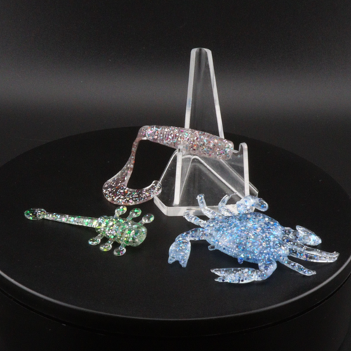 Glitter bomb fishing bait set with clear stand and pink and blue glitter lure pieces