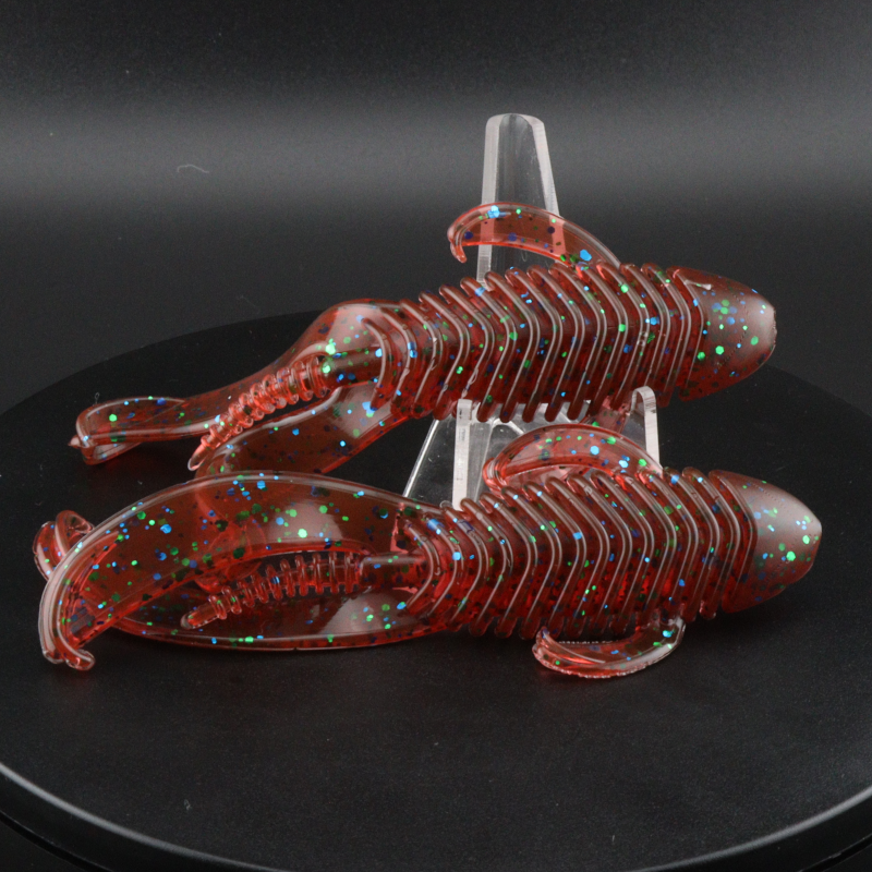 Red orange speckled soft plastic creature lures with ribbed bodies and curled tails