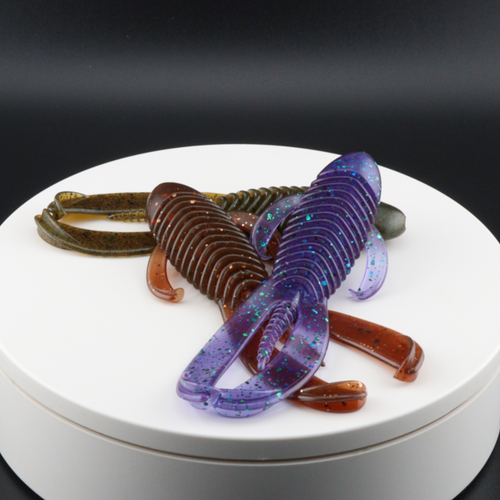 Purple and brown speckled soft plastic creature lures, ribbed bodies with tails