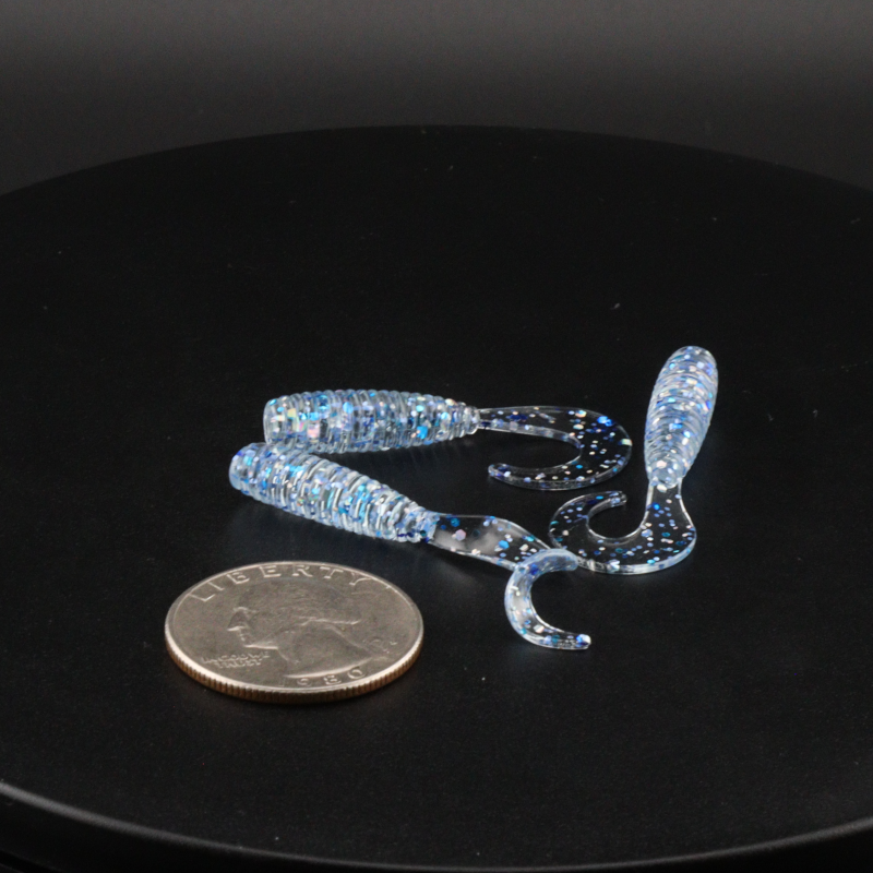 Blue glitter fishing bait lure pieces with clear stand accessory and round coin scale