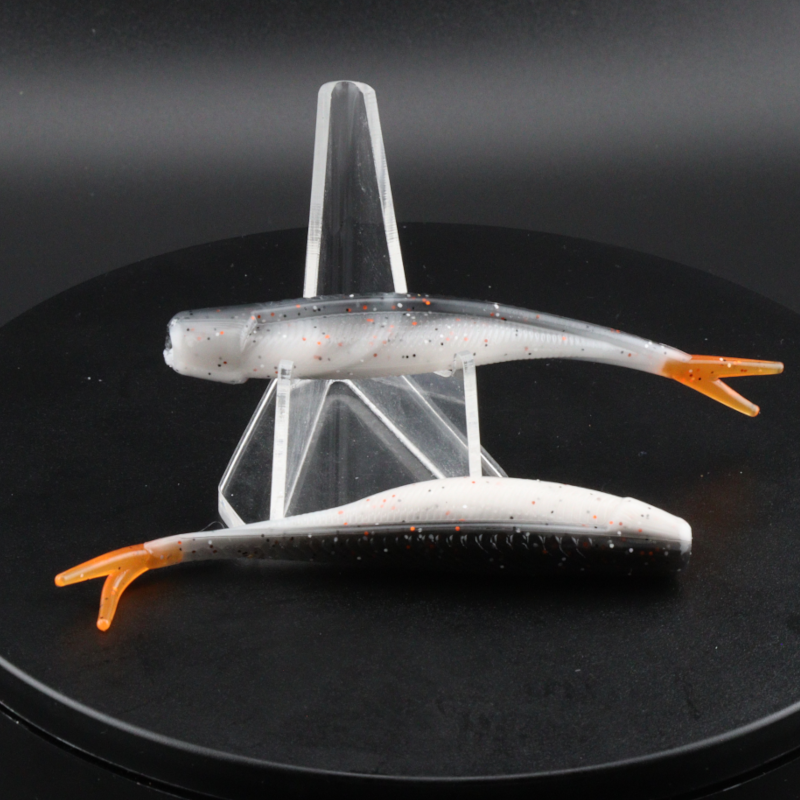 Fishing lure set: long white soft plastic lures with orange tips and speckles, in stand