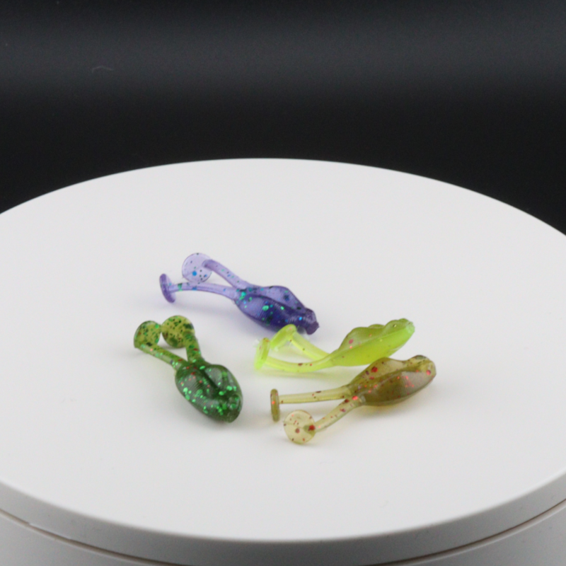 Assorted small frog fishing lures in green, purple, and red colors