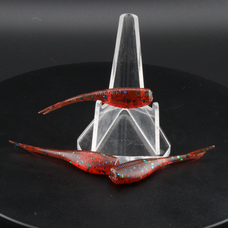 2-inch red-orange speckled soft plastic fishing lure with tail fins in clear holder