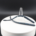 Straight tail worm lures in dark blue with turquoise speckles inside a white container