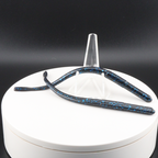 Straight tail worm lures in dark blue with turquoise speckles inside a white container