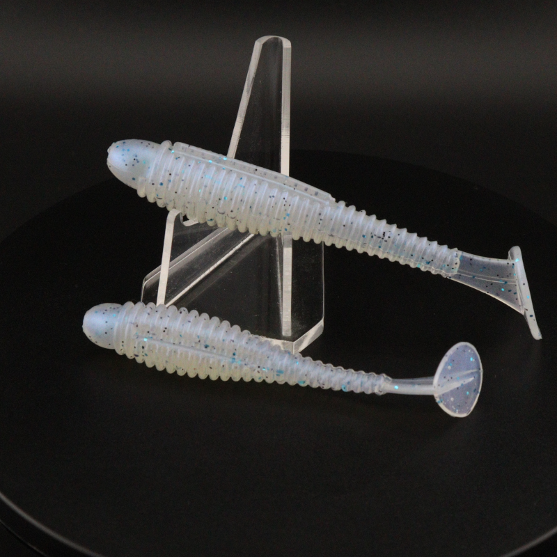 Light blue translucent soft plastic ringer fishing lures with ribbed body and curled tail