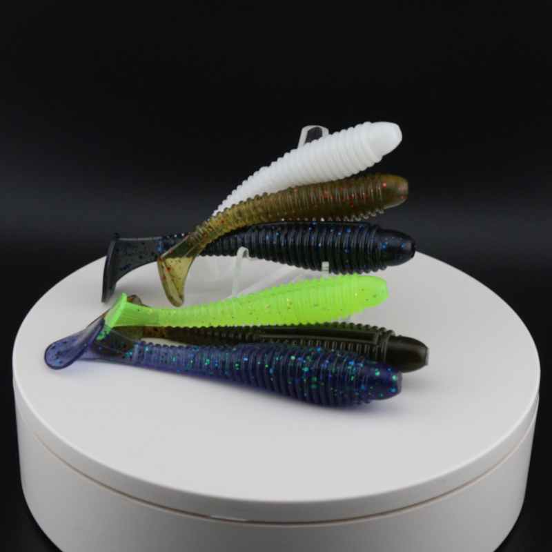 Assorted soft plastic ringer fishing lures in dark blue and green with ribbed bodies