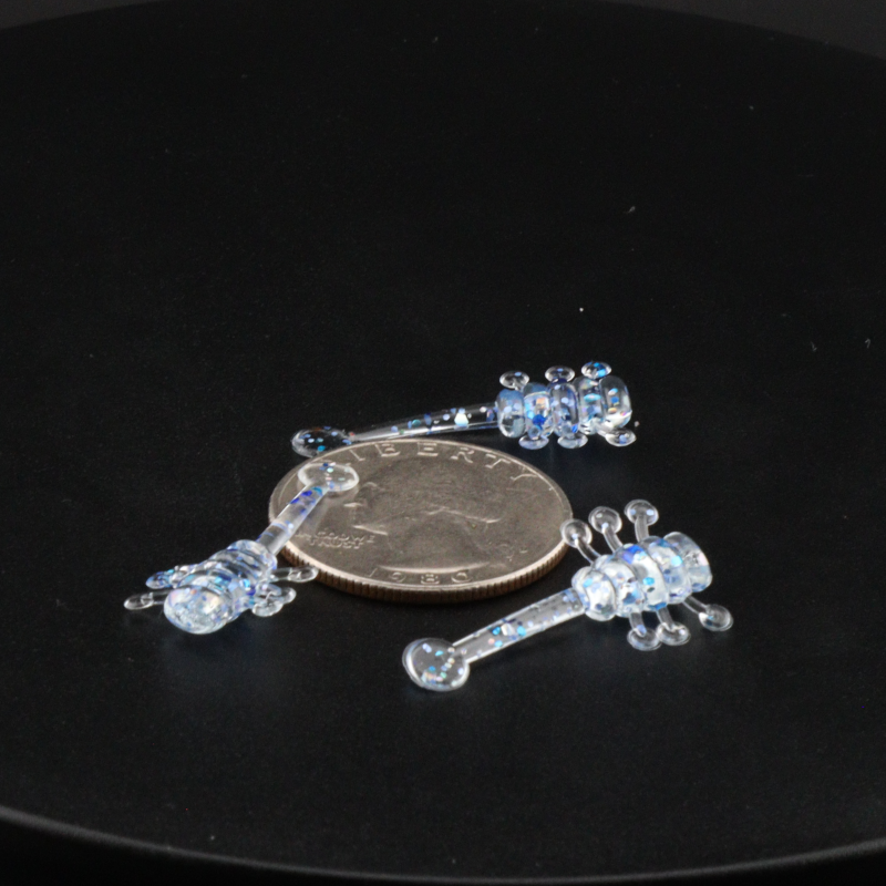 Blue glitter fishing bait lure pieces with clear stand accessory and coin scale
