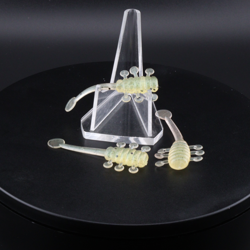 Fishing lure set with clear stand, multiple translucent green soft baits with speckles